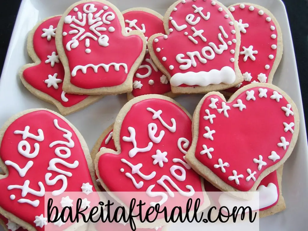 Brown Sugar and Spice cookies with royal icing decorated with the words "let It Snow" on a white plate
