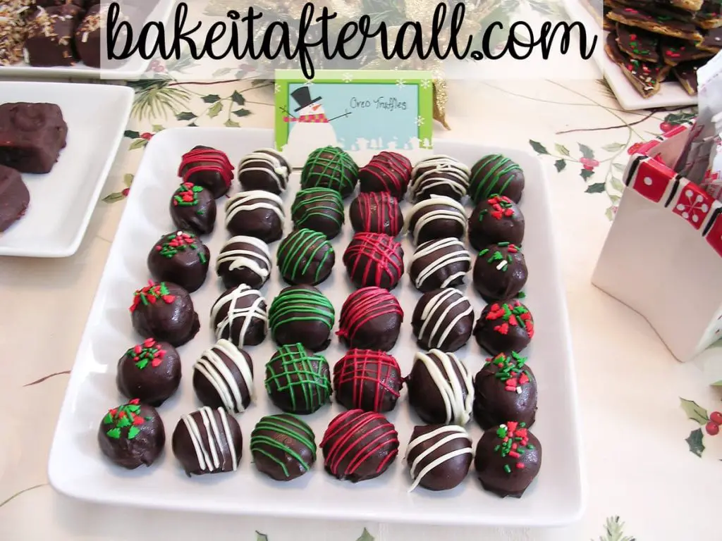 holiday oreo truffles on a platter on a holiday dessert table decorated with striped of red and green and Christmas sprinkles for a Holiday Open House