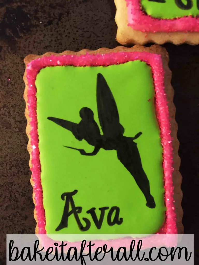 up close of a royal icing cookie with a Tinkerbell silhouette on top