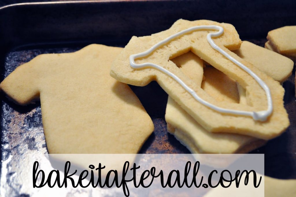Middle sugar cookie piece with a line of toothpaste consistency royal icing piped around the edges