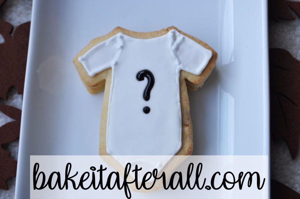 stuffed sugar cookie with white onesie design on top with black question mark