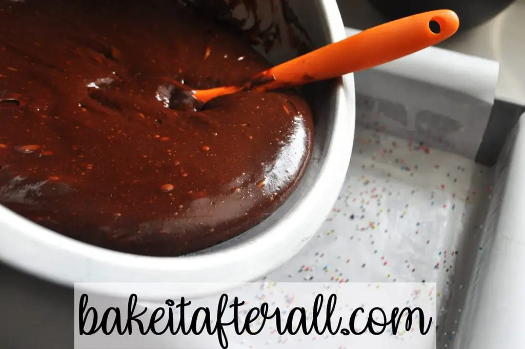 pouring brownie batter into prepared pan