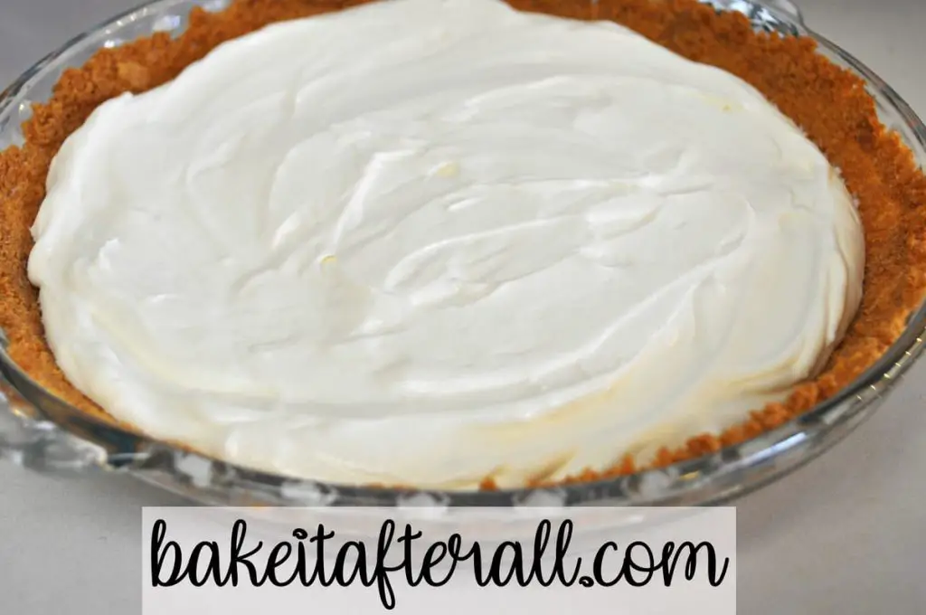 cheesecake filling inside graham cracker crust in glass pie plate on table