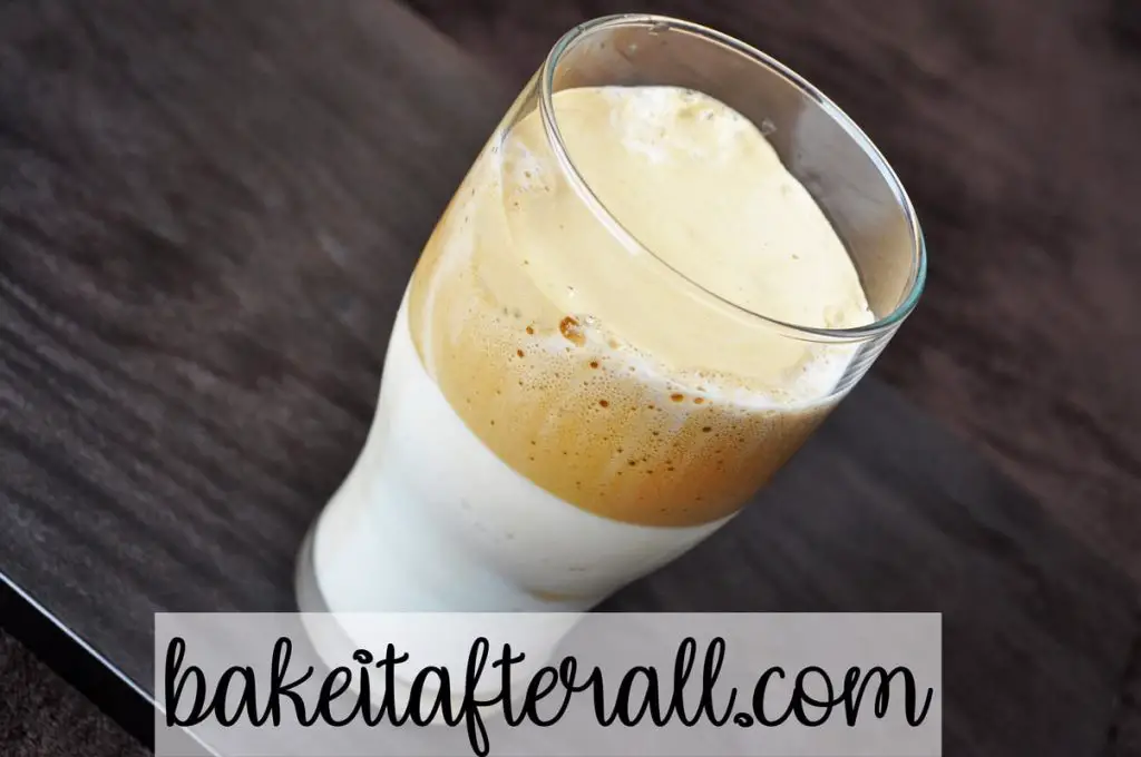 whipped coffee on top of milk in a glass