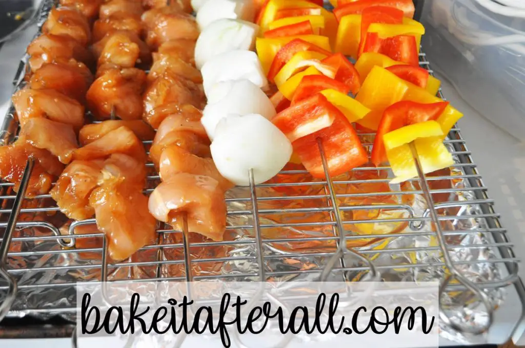 baking rack with chicken, onion, and pepper skewers on top