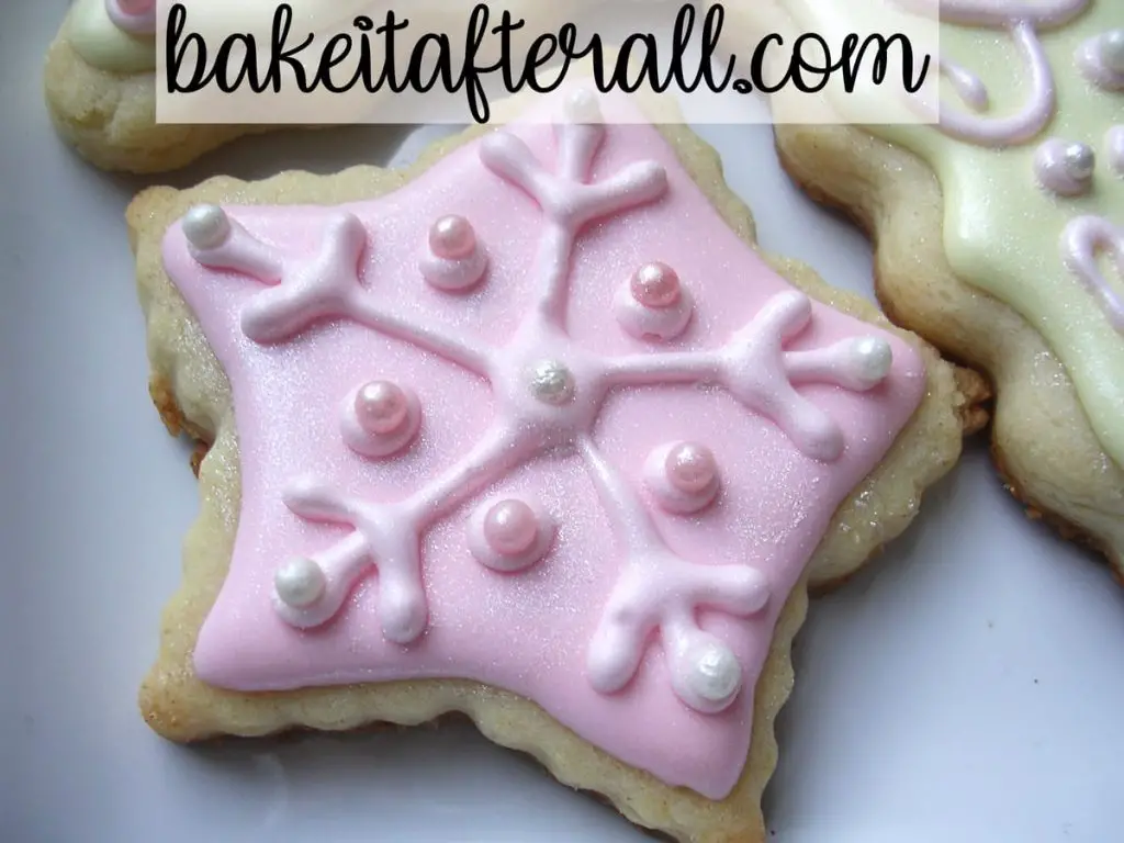 pastel pink christmas cookie shaped as a star and decorated like a snowflake
