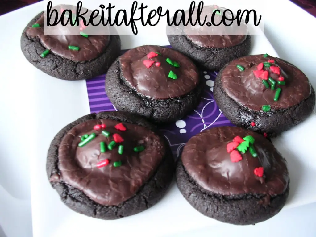 dark chocolate covered cherry cookies decorated with Christmas sprinkles on a white plate