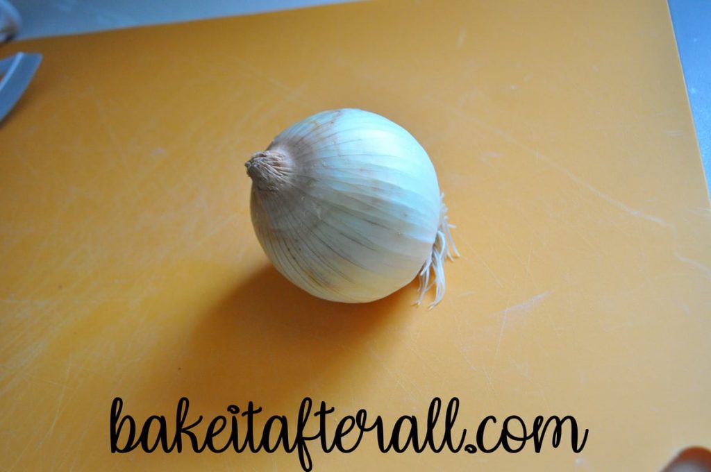 intact onion on a cutting board