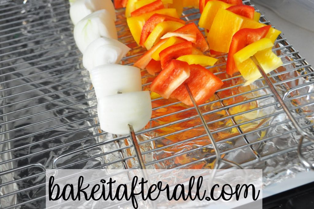 baking rack with onion and pepper skewers on top