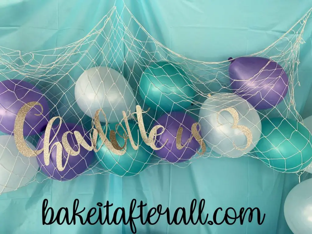 Charlotte is 3 sign on a fishing net filled with balloons for an Under the Sea Birthday Party