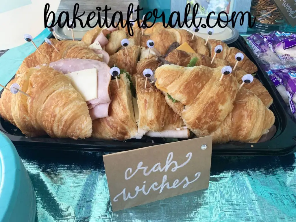 platter of Costco croissant sandwiches with googly eyes on toothpicks stuck in each