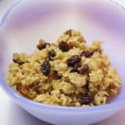 baked oatmeal in a purple bowl with raisins in it