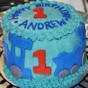 Thomas the Train smash cake on a foiled lined platter with a train track around in black food gel