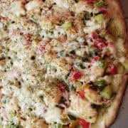 a chicken pesto pizza on a flat surface