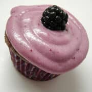 a blackberry vanilla cupcake on a white surface