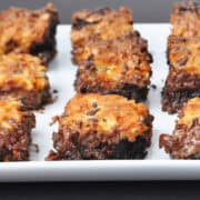 a white plate filled with coconut butterscotch chip brownies