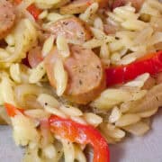 ale braised sausage and peppers with orzo on a plate