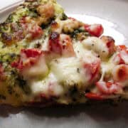 a slice of chicken pizza with a nut free pesto sauce