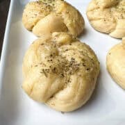 soft garlic knots on a white plate