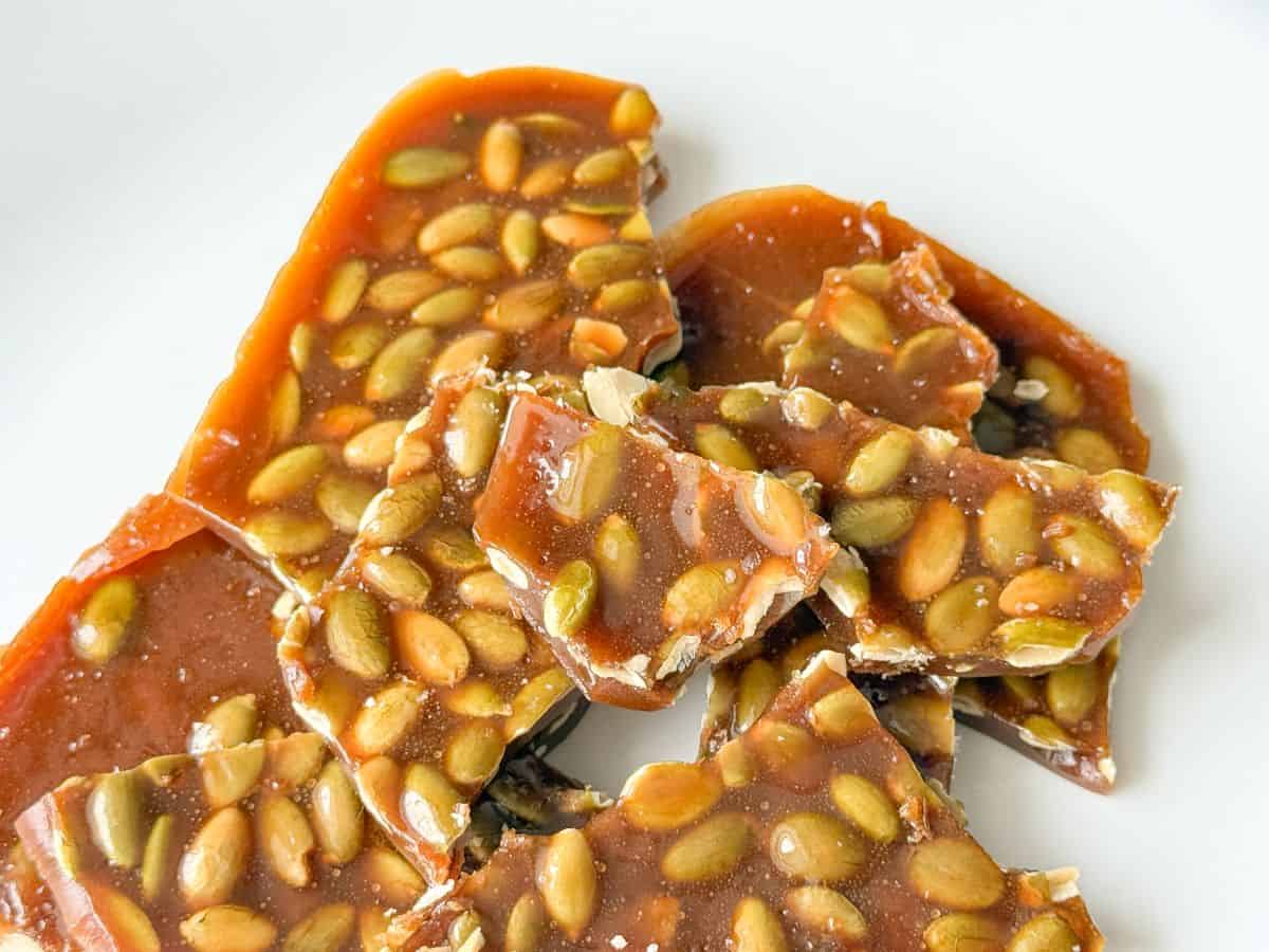 pieces of Nut Free Pumpkin Seed Brittle on a white plate