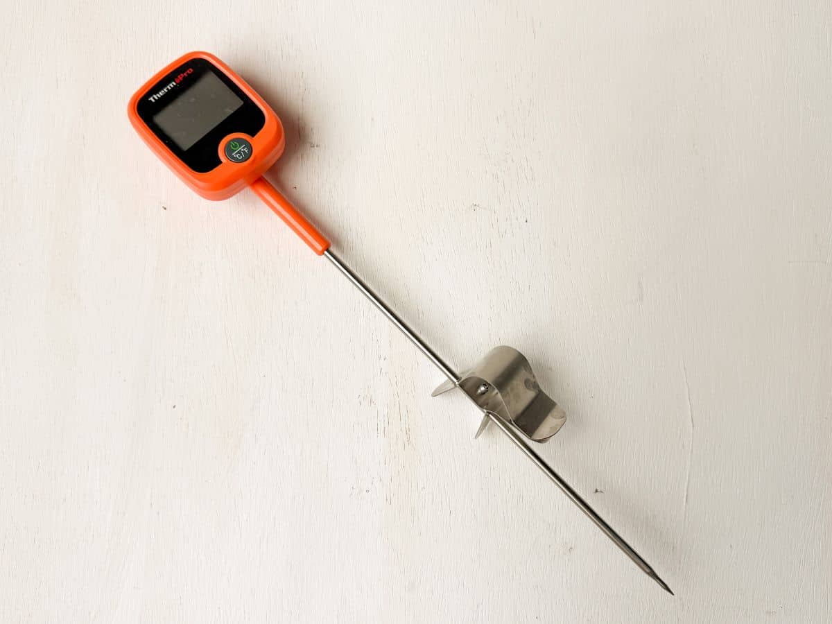 a digital candy thermometer on a white wood surface
