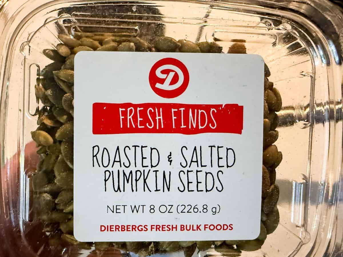 a container of roasted and salted pumpkin seeds