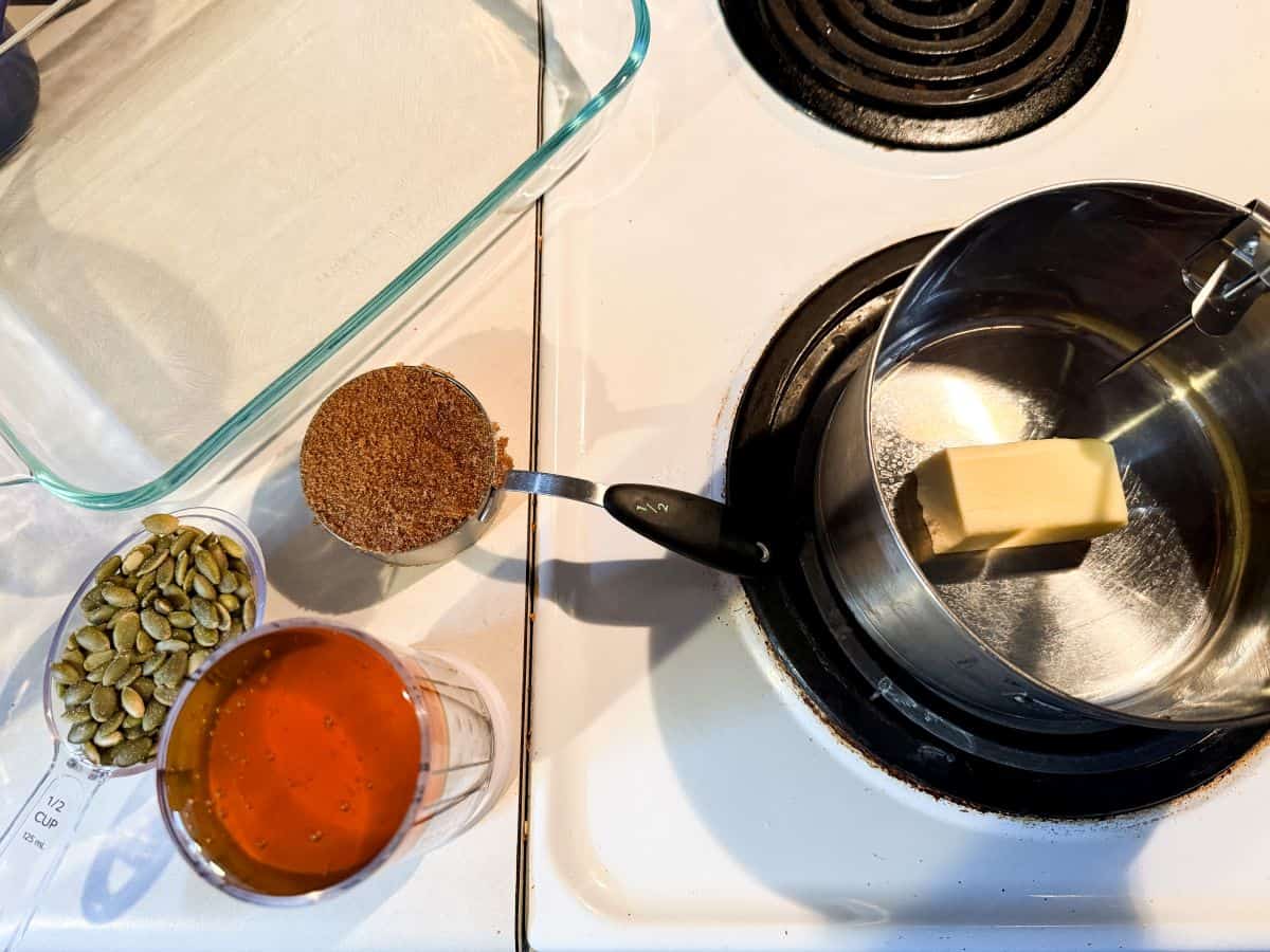 nut free pumpkin seed brittle ingredients next to a pan melting butter