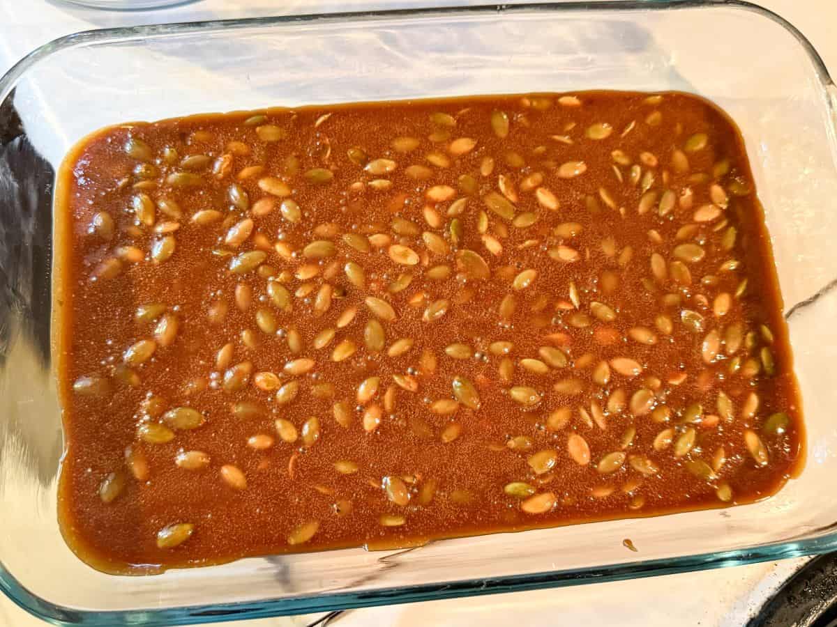 nut free pumpkin seed brittle poured into a glass dish