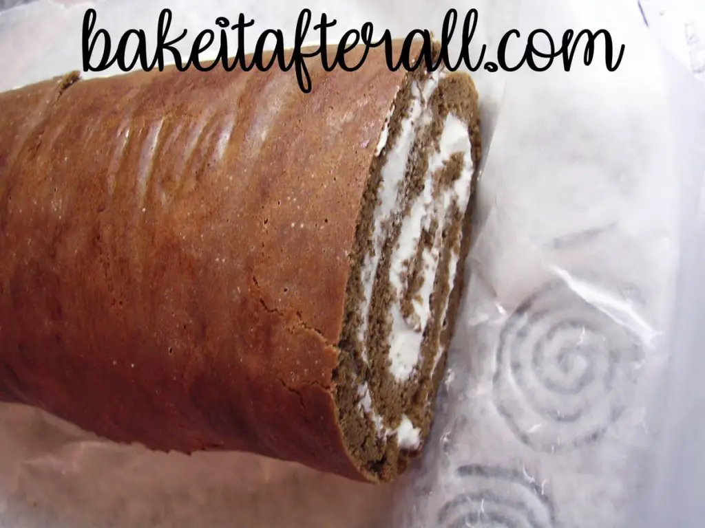 unfrosted cloud roll cake with whipped cream inside with end cut off and placed on top to be a knot in the wood