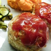 turkey meatloaf muffins on a plate with sauteed zucchini on the side