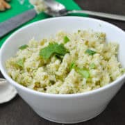 cilantro coconut rice in a white bowl with cilantro leaves on top