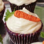 a carrot cupcake with cream cheese frosting and a nut free marzipan carrot on top