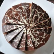 mocha cream cake on a white cake platter with a brown background