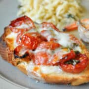 oven dried tomato bruschetta on a plate with orzo and shrimp
