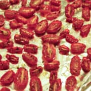 a foil lined pan with oven dried tomatoes on it