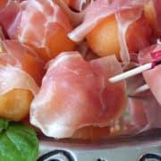 prosciutto and melon bite sized appetizers on a platter