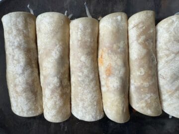 enchiladas rolled up in a glass dish