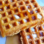 Pumpkin waffles on a plate with butter and syrup