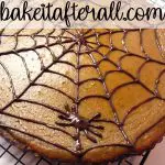pumpkin chocolate tart with a chocolate spider web design on top
