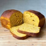 Pumpkin Yeast Bread sliced on a wooden cutting board