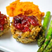 turkey pumpkin meatloaf muffins, asparagus, and mashed sweet potatoes on a white plate