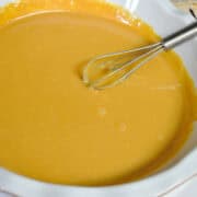 dulce de leche in a pie plate with a small whisk