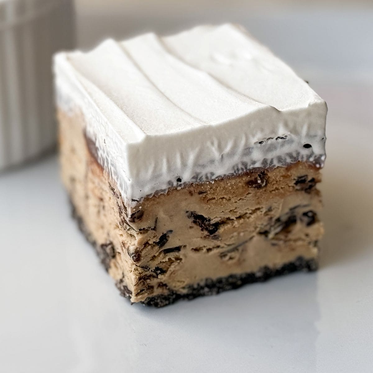 a square of caramel espresso chip ice cream cake on a white plate