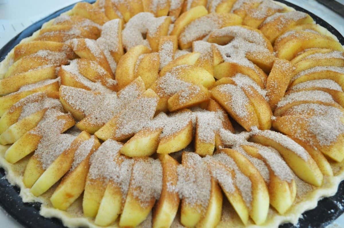 pie crust with sliced apples and cinnamon sugar sprinkled on top