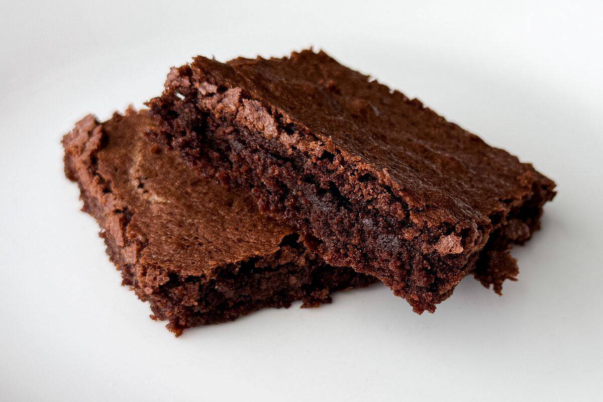 two dairy free soy free brownies stacked on a white plate