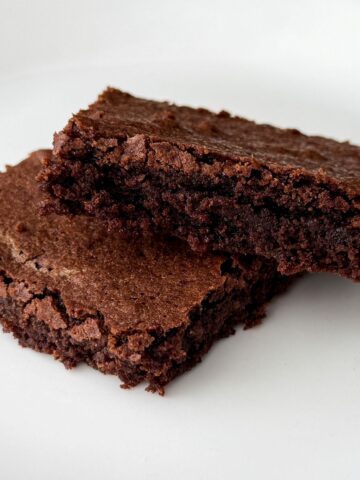 two dairy free soy free brownies stacked on a white plate
