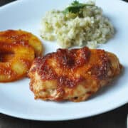 a plate with Huli Huli chicken, a pineapple ring and cilantro coconut rice
