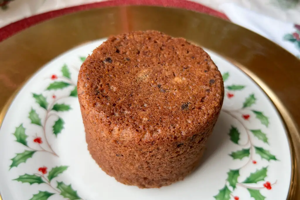 an unmolded figgy pudding on a holiday plate