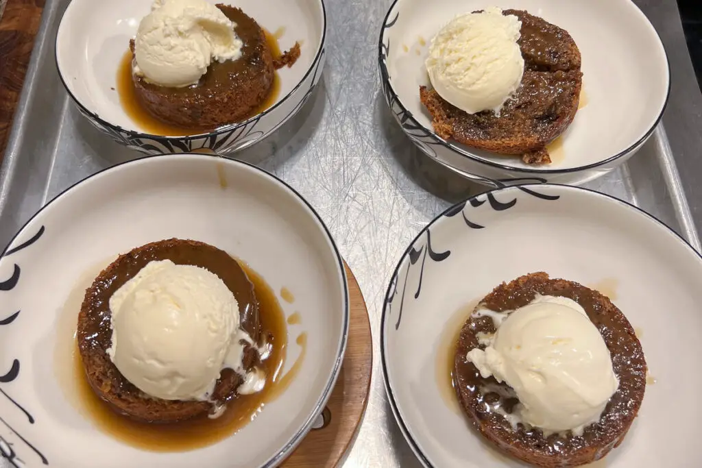 figgy puddings in individual bowls with sauce and ice cream