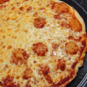 a cheese thin crust pizza on a pizza pan
